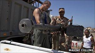 Anti-Gaddafi forces standing in a truck with a gun mounted on it