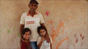 Eid Jahalin with his two daughters outside the tyre school