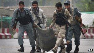 Afghan security forces carry the body of a colleague, who was killed during a gun battle with Taliban militants in Kabul, Afghanistan, 14 Sept 2011