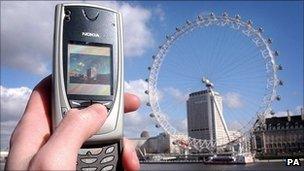 A mobile phone is used to take a picture of the London Eye