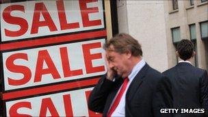 City worker walks past a sale sign