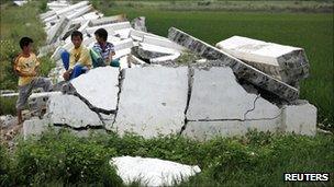 Villagers from Longtou in Lufeng play on the rubble of a surrounding wall after it was torn down by villagers earlier in the week on 24 September 2011.