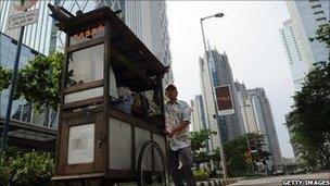 A food vendor pushes his cart at Jakarta