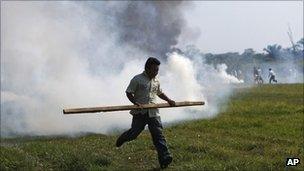 A man runs for cover after riot police fired tear gas canister during a protest in Rurrenabaque, Bolivia, Monday 26 September 2011