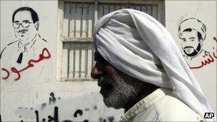 A man passes graffiti of jailed Bahraini opposition figures in Malkiya, Bahrain, 28 September 2011