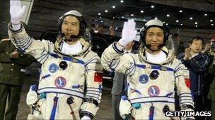 Chinese astronauts Fei Junlong (L) and Nie Haisheng wave before boarding the Shenzhou VI spacecraft at Jiuquan Satellite Launch Center on 12 October 2005 in Jiuquan, Gansu province, northwest China