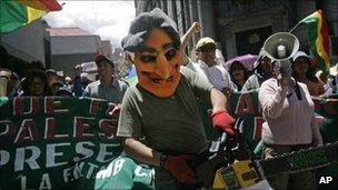 A demonstrator wearing an Evo Morales mask and holding a chainsaw marches in La Paz, Bolivia