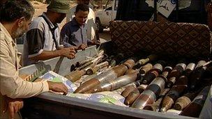 Men look at unexploded shells in Zlitan