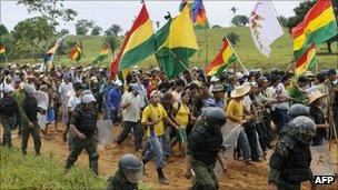 Bolivian protesters with flags flanked by riot police, 24 September