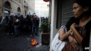 Italian people take shelter from clashes between police and protesters