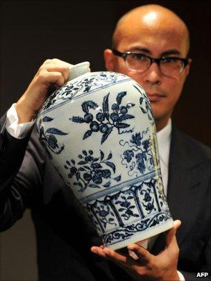 The head of Sotheby's Chinese Ceramics Department, Nicholas Chow, displaying a Ming Dynasty blue and white vase with fruit sprays