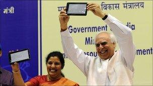 Indian Human Resource Development (HRD) Minister Kapil Sibal (R) and Junior HRD Minister D. Purandeswari (L) pose with Aakash tablet after its launch in Delhi on October 5, 2011.