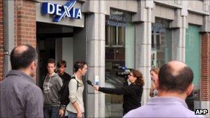 A Dexia customer is interviewed by the local media in Tournai, Belgium