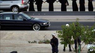 Bahrain police watch as a group of women start a human chain protest in Manama, 4 October 2011