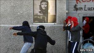 Masked protesters throwing stones at police during a protest on 29 September