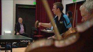 Violinists playing alongside table tennis match