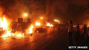 Protesters on street, fire.