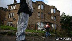 Children playing football near boarded up houses