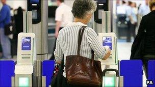 A woman uses a new scanner at Gatwick Airport