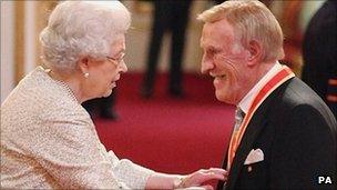 Sir Bruce Forsyth receives his knighthood from the Queen