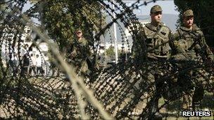 German peacekeeping troops walk beside a barricade on the main bridge in the divided Kosovan town of Mitrovica, 5 October