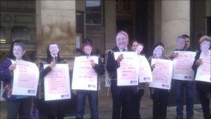 Unison members wearing masks of council executives whose pay is unaffected by the changes to workers contracts outside Birmingham City Council