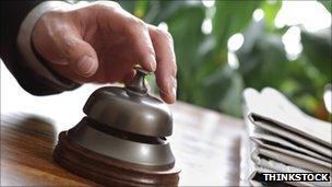 A guest presses a hotel reception bell