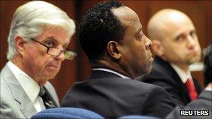 Dr Conrad Murray defence attorneys J. Michael Flanagan and Nareg Gourjian look at him during his trial, Los Angeles 12 October 2011.