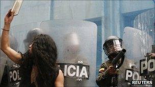A student protester confronts riot police during a demonstration in Bogota, 12 October 2011