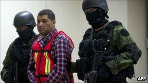 Mexican Army soldiers hold Carlos Oliva Castillo, aka "La Rana", in front of the press at the National Defence Secretaryship headquarters in Mexico City, on 13 October 2011