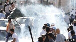 Protesters run for cover after police fired tear gas in Tunis. Photo: 14 October 2011