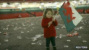 A three year old girl still holding the flag after the defeat