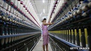 A worker operates machines for making yarn at a textile factory in China's Anhui province