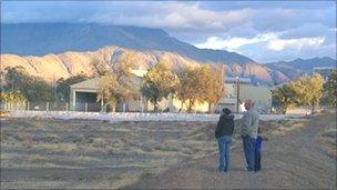 Family stands on a dirt berm overlooking the shuttered town of Empire