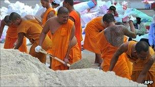 Buddhist monks help fill sandbags in Pathum Thani, Bangkok (19 Oct 2011)