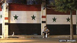 Closed shops with shutters painted in the colours of the Syrian national flag