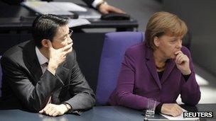 German Chancellor Angela Merkel (right) and Economy Minister Philipp Roesler attend a session of the German parliament in Berlin, 21 October