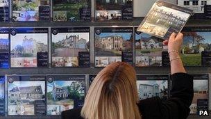 Woman looking in estate agent's window