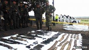 Policemen and soldiers look at rifles, mortars and grenade launchers seized from Farc guerrillas in Cucuta on 11 October 2011.