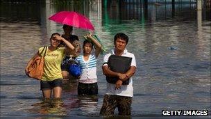 Thai residents make their way through the flooded streets October 21, 2011 in Pathumthani on the outskirts of Bangkok