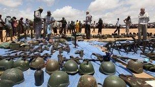 Islamic militants display weapons and equipment of African soldiers they killed in clashes in Mogadishu