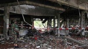A soldier stands guard next to the damaged UN headquarters in Abuja (27 August 2011)