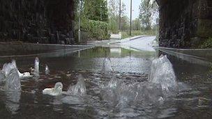 water swelling up from man hole covers