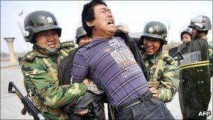 Chinese police make a mock arrest during a drill rehearsing how to control demonstrations in Urumqi, in far-western Xinjiang province, on 1 April 2011