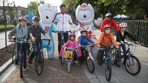 Five-time Olympic swimmer Mark Foster with children and London 2012 Mascots Wenlock and Mandeville on an enhanced cycle scheme in Hackney, London, pic courtesy of ODA