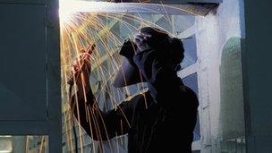 welder stands in a shower of sparks