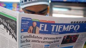 Man reading copy of El Teimpo newspaper with headline: Candidates promise anticorruption fight