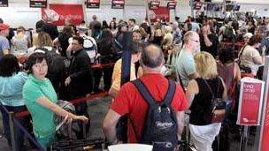 Passengers queue at Virgin Australia check-in counters at Perth airport