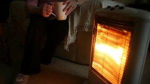 A heater and a man holding a cup of tea