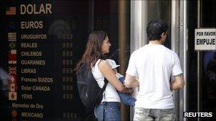 A couple wait outside a closed foreign exchange house in the Argentine capital, Buenos Aires